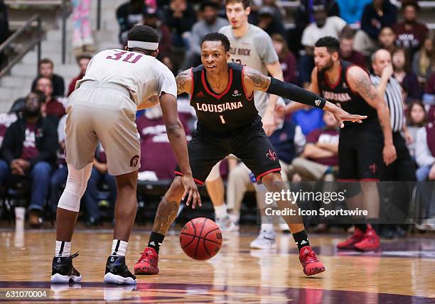 Louisiana Lafayette Ragin Cajuns guard Jay Wright defends against Arkansas Little Rock Trojans guard Deondre Burns during an NCAA basketball game...