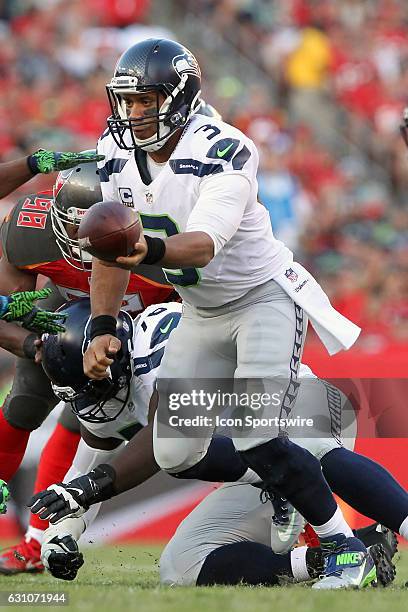 Russell Wilson of the Seahawks turns to hand the ball to wide receiver Tyler Lockett during the NFL Game between the Seattle Seahawks and Tampa Bay...