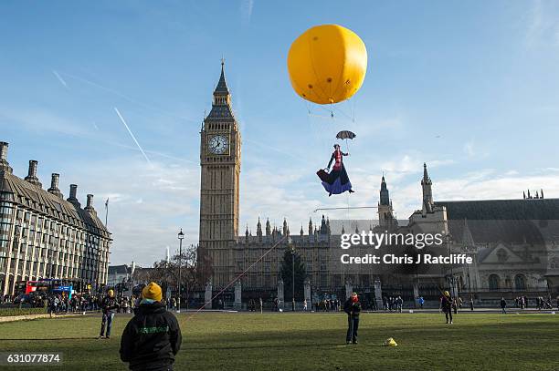 Greenpeace activists float a picture of Mary Poppins wearing a gas mask in front of the Houses of Parliament to highlight that London has breached...