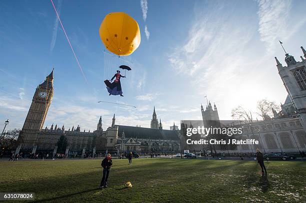 Greenpeace activists float a picture of Mary Poppins wearing a gas mask in front of the Houses of Parliament to highlight that London has breached...