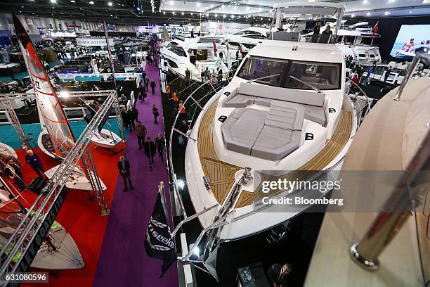 Visitors pass the front deck of a Manhattan 66 yacht, manufactured by Sunseeker International Ltd., at the London Boat Show in London, U.K., on...