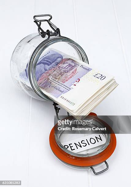 glass jar with twenty pound notes labelled pension - 401k engels woord stockfoto's en -beelden
