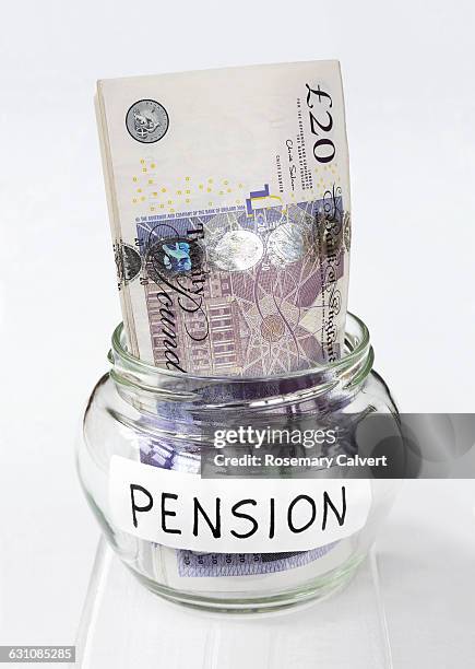 jar labelled pension with twenty pound notes in it - saving for a rainy day englische redewendung stock-fotos und bilder