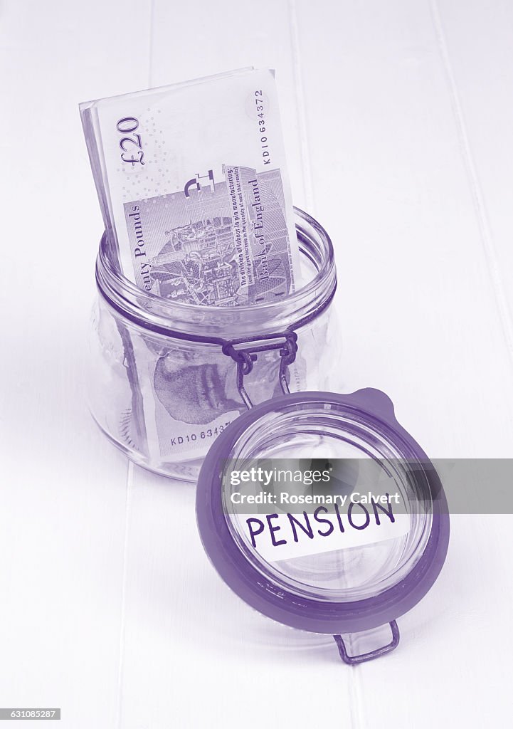 Jar & twenty pound notes in monochromatic purple