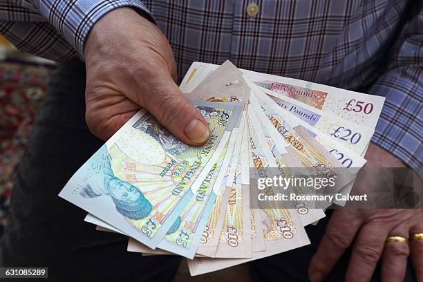 pensioner holding british bank notes in right hand - twenty pound note 個照片及圖片檔