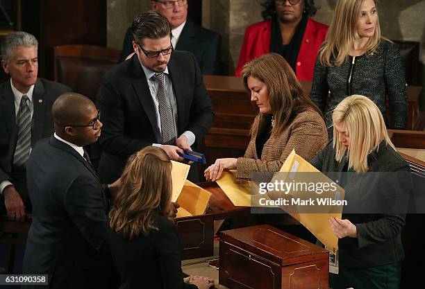 Staffers organize states ballots during the counting of the electoral votes from the 2016 presidential election during a joint session of Congress,...