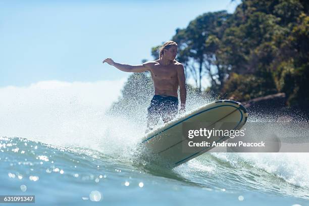 a man is surfing a longboard, tea tree bay - noosa heads stock pictures, royalty-free photos & images