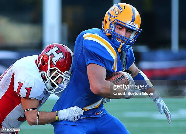 Chicopee's Mason Labonte carries the ball after a short second quarter gain as he is brought down by Holliston's Matthew McIsaac. Holliston faces...