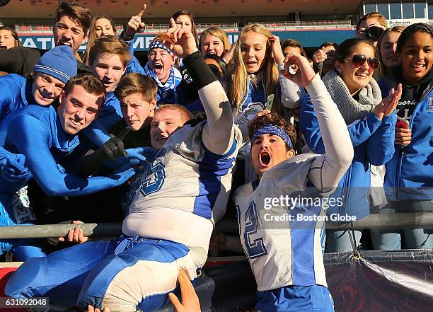 Mashpee's Andrew Vinitsky, left, and Emmett Sweeney jump into the stands with Mashpee fans at the end of the game in which they beat St. Bernard's....