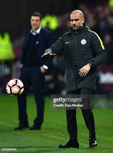 Josep Guardiola, Manager of Manchester City throws the ball back into play during The Emirates FA Cup Third Round match between West Ham United and...