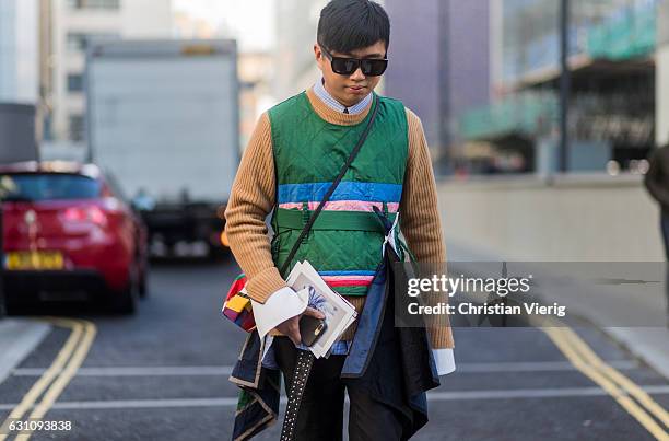 Declan Chan wearing Alexander Wang pants, a Craig Green vest, Loewe bag, a beige Wooyoungmi knit black sunglasses during London Fashion Week Men's...