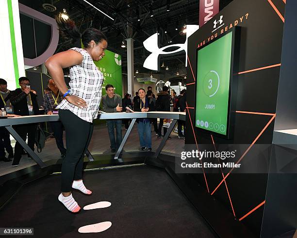 Latisha Tillie tries out a jump test at the Under Armour booth at CES 2017 at the Sands Expo and Convention Center on January 6, 2017 in Las Vegas,...