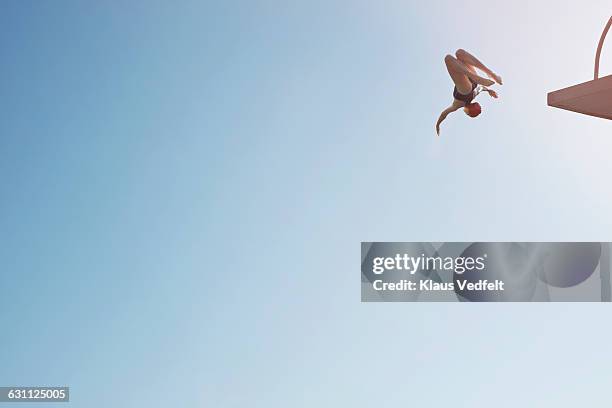 woman doing somersault from diving platform - wurf oder sprungdisziplin damen stock-fotos und bilder