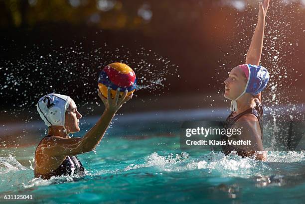 waterpolo players battling to get the ball - wasserball stock-fotos und bilder