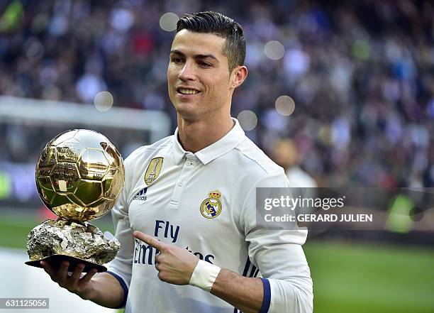 Real Madrid's Portuguese forward Cristiano Ronaldo poses with the Ballon d'Or France Football trophy before the Spanish league football match Real...