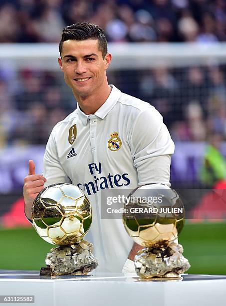 Real Madrid's Portuguese forward Cristiano Ronaldo poses with two of his four Ballon d'Or France Football trophies before the Spanish league football...