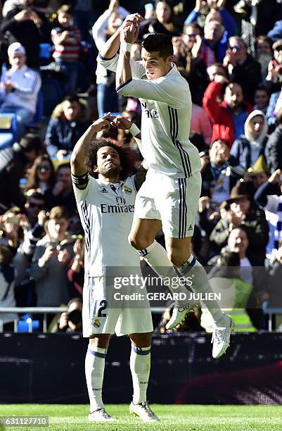 Real Madrid's Portuguese forward Cristiano Ronaldo celebrates past Real Madrid's Brazilian defender Marcelo after scoring during the Spanish league...