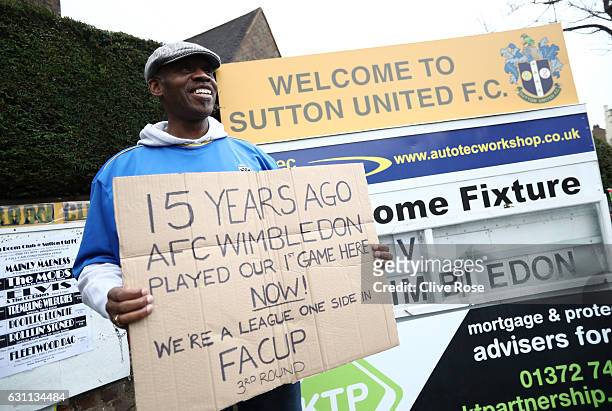 An AFC Wimbledon supporter holds up a sign prior to The Emirates FA Cup Third Round match between Sutton United and AFC Wimbledon at the Borough...
