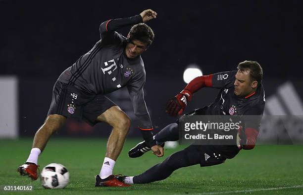 Thomas Mueller is challenged by goalkeeper Manuel Neuer during a training session at day 5 of the Bayern Muenchen training camp at Aspire Academy on...