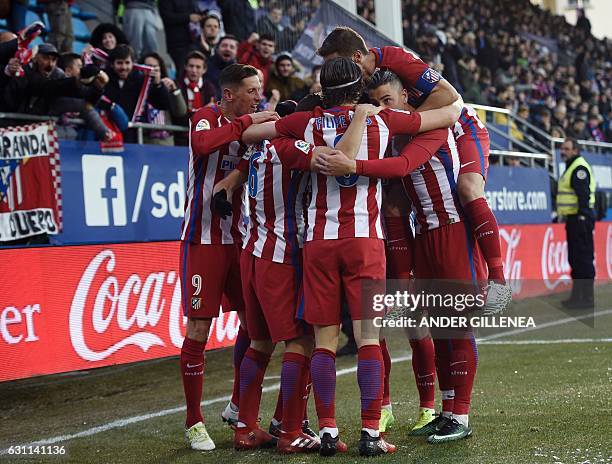 Atletico Madrid's players celebrate after midfielder Saul Niguez scored his team's first goal during the Spanish league football match SD Eibar vs...