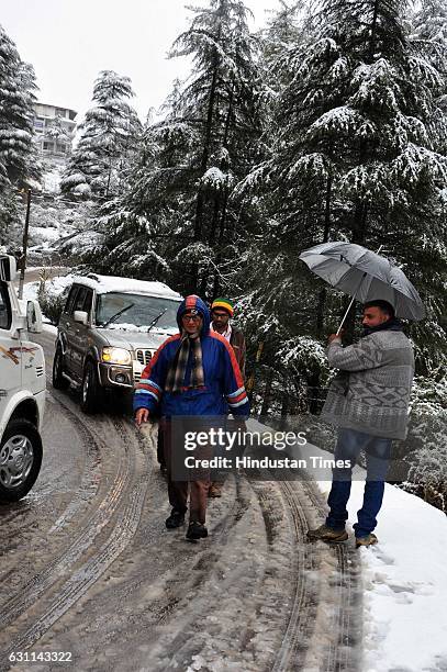 Tourists walk alongside traffic in the first snow fall of the season, in Naddi Dal Lake, on January 7 2017 in Dharamsala, India. Winter’s first heavy...