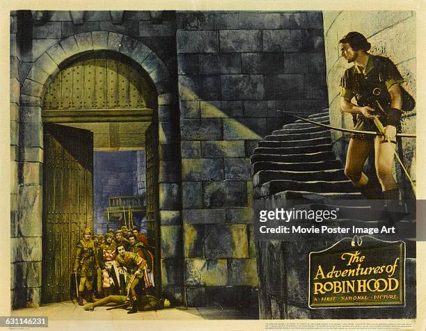 Actors Errol Flynn and Basil Rathbone appear on a poster for the 1938 adventure film 'The Adventures of Robin Hood', produced by Warner Bros.