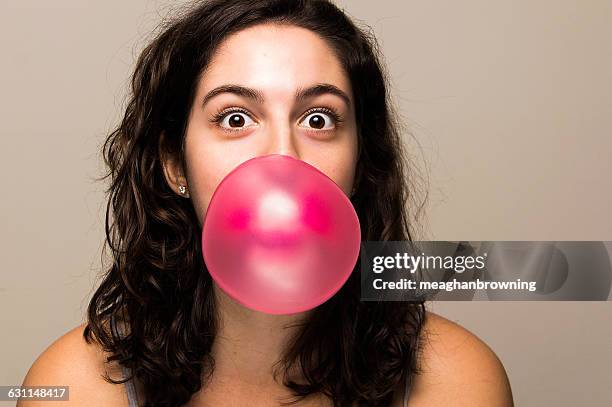 young woman blowing bubble gum bubble - bubble gum ストックフォトと画�像