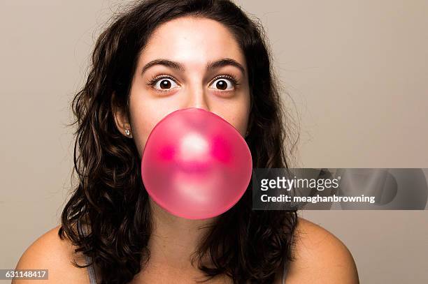 young woman blowing bubble gum bubble - bubble gum bubble stock pictures, royalty-free photos & images