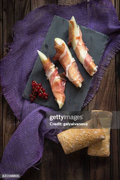 melon wrapped in parma ham with bread - prosciutto wrapped stock pictures, royalty-free photos & images