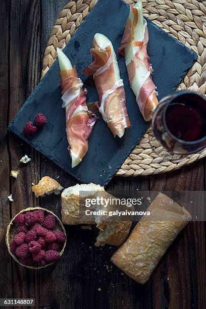 melon wrapped in parma ham with bread - prosciutto wrapped stock pictures, royalty-free photos & images