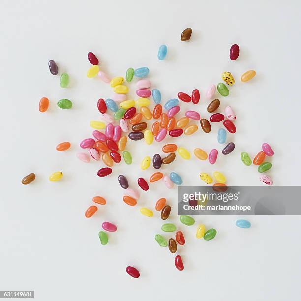 multi-colored jelly beans on a white table - jelly beans stock pictures, royalty-free photos & images
