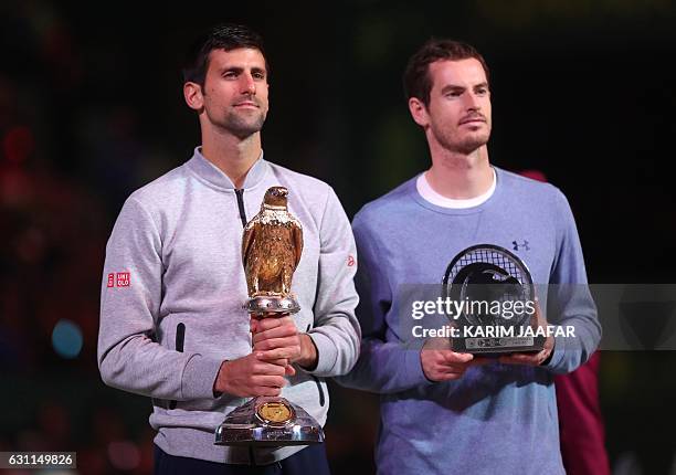 Serbia's Novak Djokovic poses with the winner's trophy after beating Britain's Andy Murray during their final tennis match at the ATP Qatar Open in...