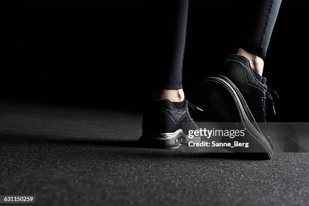 close-up of woman's legs in trainers at gym - ropa de deporte fotografías e imágenes de stock