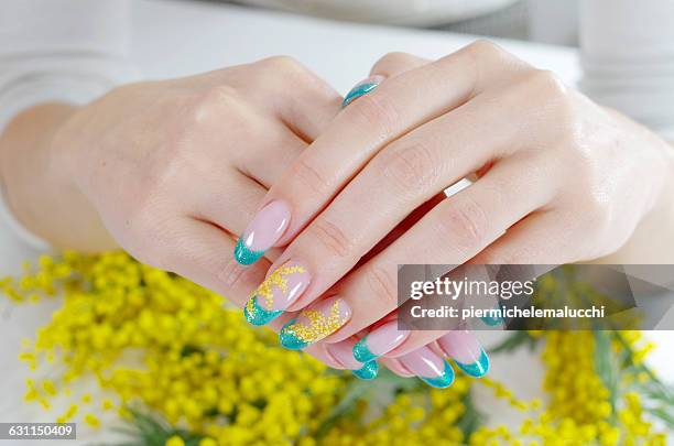 woman's hands with floral nail art design - nagelkunst stockfoto's en -beelden