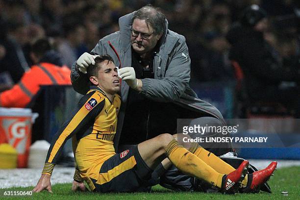Arsenal's Brazilian defender Gabriel has a cut treated during the English FA Cup third round football match between Preston North End and Arsenal at...