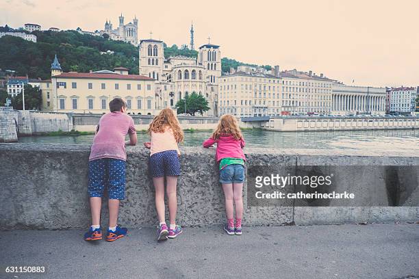 Three children looking at cathedral and River Saone, Lyon, France