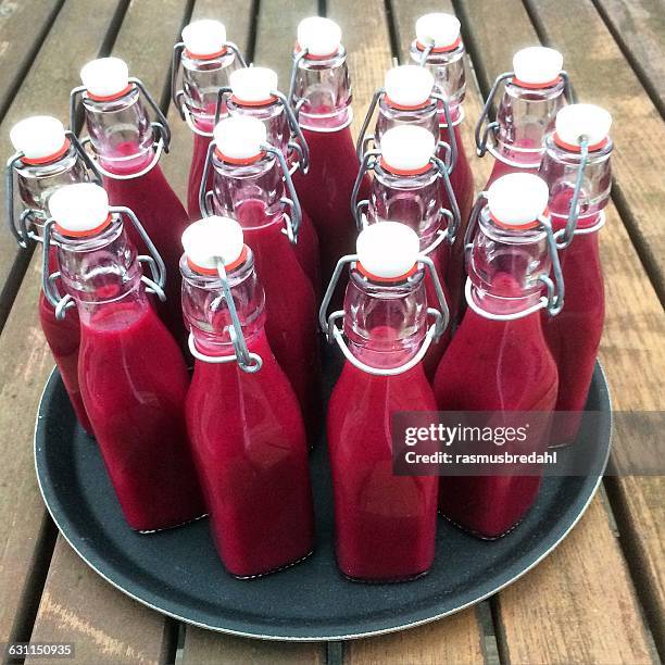 bottles of beetroot, ginger and acai berry juice drink - beetroot juice stockfoto's en -beelden