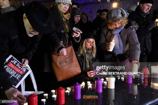 Members of the public light candles during a rally commemorating the second anniversary of the deadly attack against the satirical weekly Charlie...