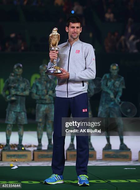 Novak Djokovic of Serbia celebrates with the trophy after winning the men's singles final of the ATP Qatar Open tennis competition against Andy...