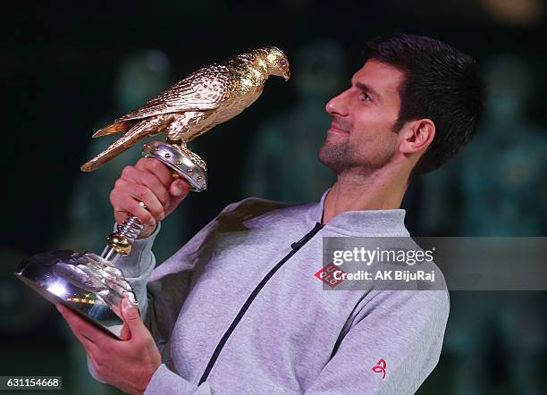 Novak Djokovic of Serbia celebrates with the trophy after winning the men's singles final of the ATP Qatar Open tennis competition against Andy...