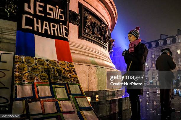 Woman prays next to a sign reading &quot;I am Charlie&quot; during a rally commemorating the second anniversary of the deadly attack against the...