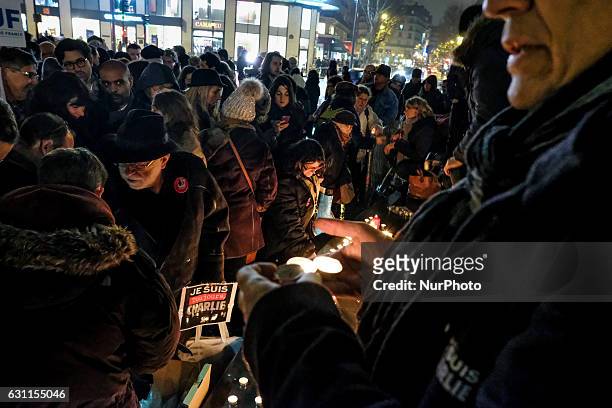 Members of the public light candles during a rally commemorating the second anniversary of the deadly attack against the satirical weekly Charlie...