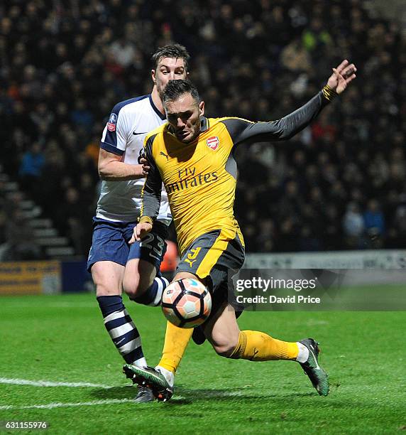 Lucas Perez of Arsenal under pressure from Paul Huntington of Preston during the match between Preston North End and Arsenal at Deepdale on January...