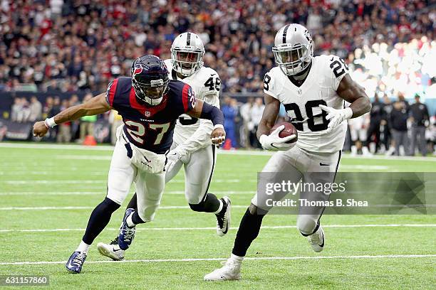 Latavius Murray of the Oakland Raiders eludes Quintin Demps of the Houston Texans for a touchdown in the AFC Wild Card game at NRG Stadium on January...