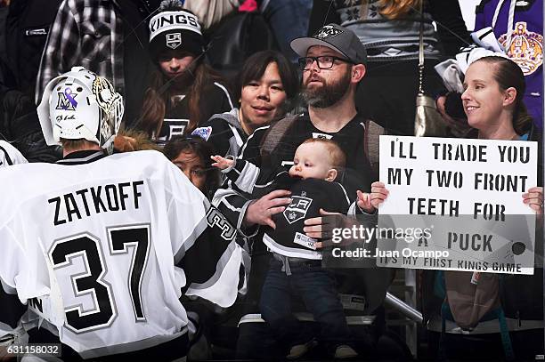 Jeff Zatkoff of the Los Angeles Kings tosses a puck to a young fan during warm-ups prior to the game against the Minnesota Wild on January 7, 2017 at...