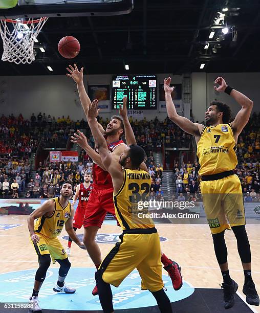 Danilo Barthel of Muenchen is challenged by Johannes Thiemann and Drew Crawford of Ludwigsburg during the easyCredit BBL match between MHP Riesen...