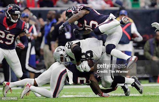 Clive Walford of the Oakland Raiders is tackled after catching a pass during the second quarter of the AFC Wild Card game against the Houston Texans...