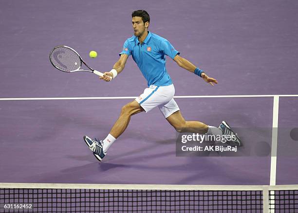 Novak Djokovic of Serbia returns the ball to Andy Murray of Great Britain during the men's singles final match of the ATP Qatar Open tennis...