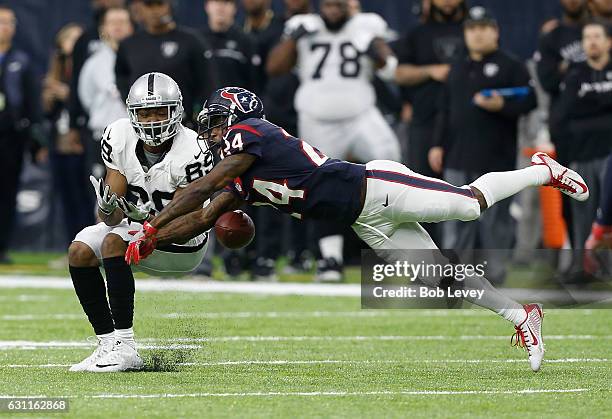 Johnathan Joseph of the Houston Texans breaks up a pass to Amari Cooper of the Oakland Raiders during the first half of their AFC Wild Card game at...