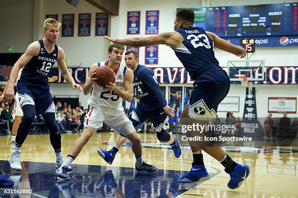 St. Mary's Gaels guard Joe Rahon surrounded in the paint by Brigham Young Cougars forward Eric Mika , Brigham Young Cougars forward Yoeli Childs ,...